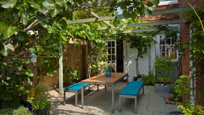 pergola with dining table in a back garden