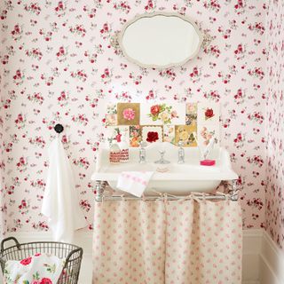 Vintage rose bathroom with pink and red floral wallpaper and white vanity sink
