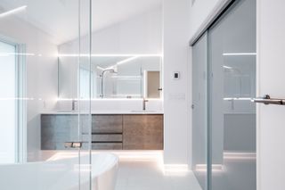 A bathroom with light along the floor and walls