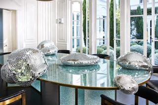Seemingly melting disco balls on a table, speciall edition of Quelle Fête by Rotganzen for the online Kelly Wearstler shop
