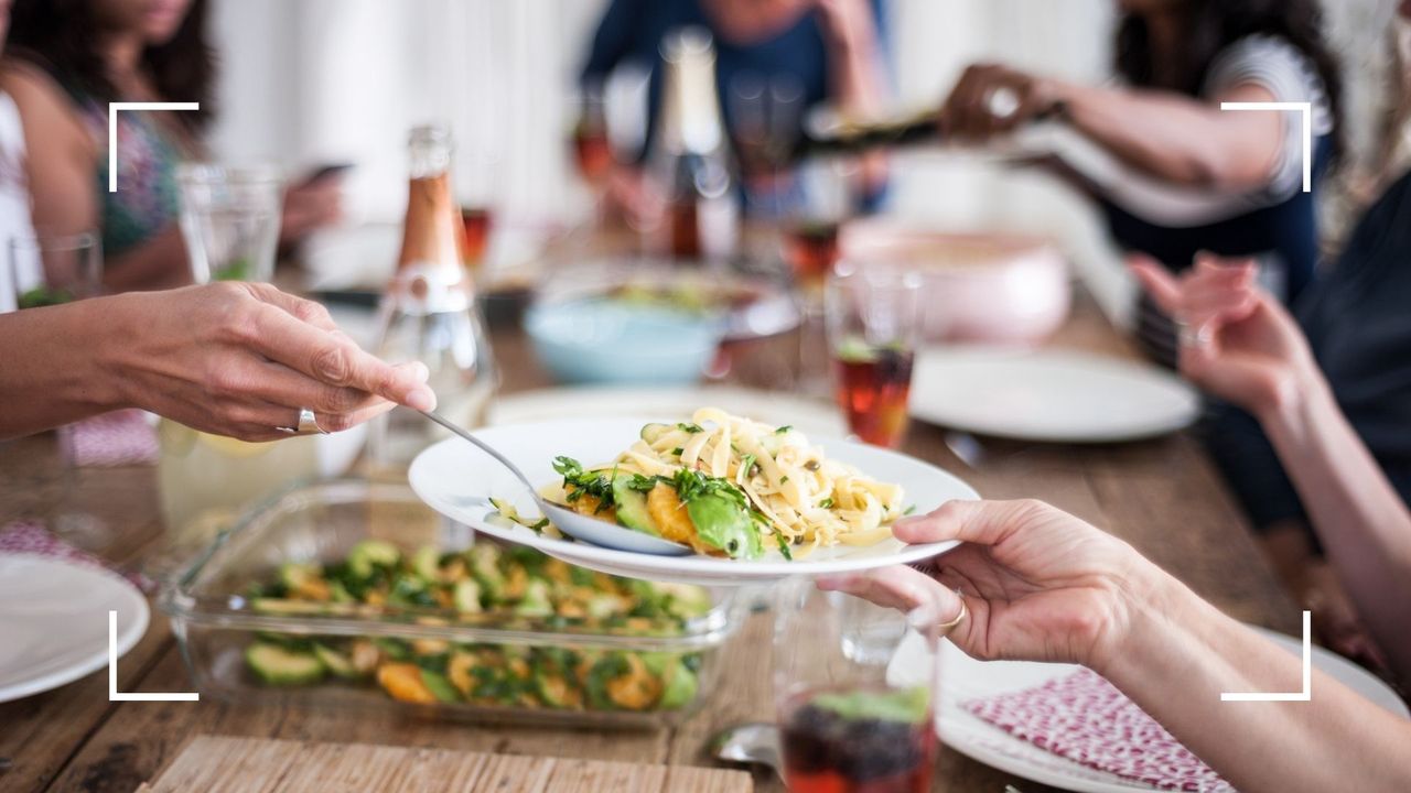 Woman holding out plate ready to be served with food at a table, after learning about eating the same thing every day