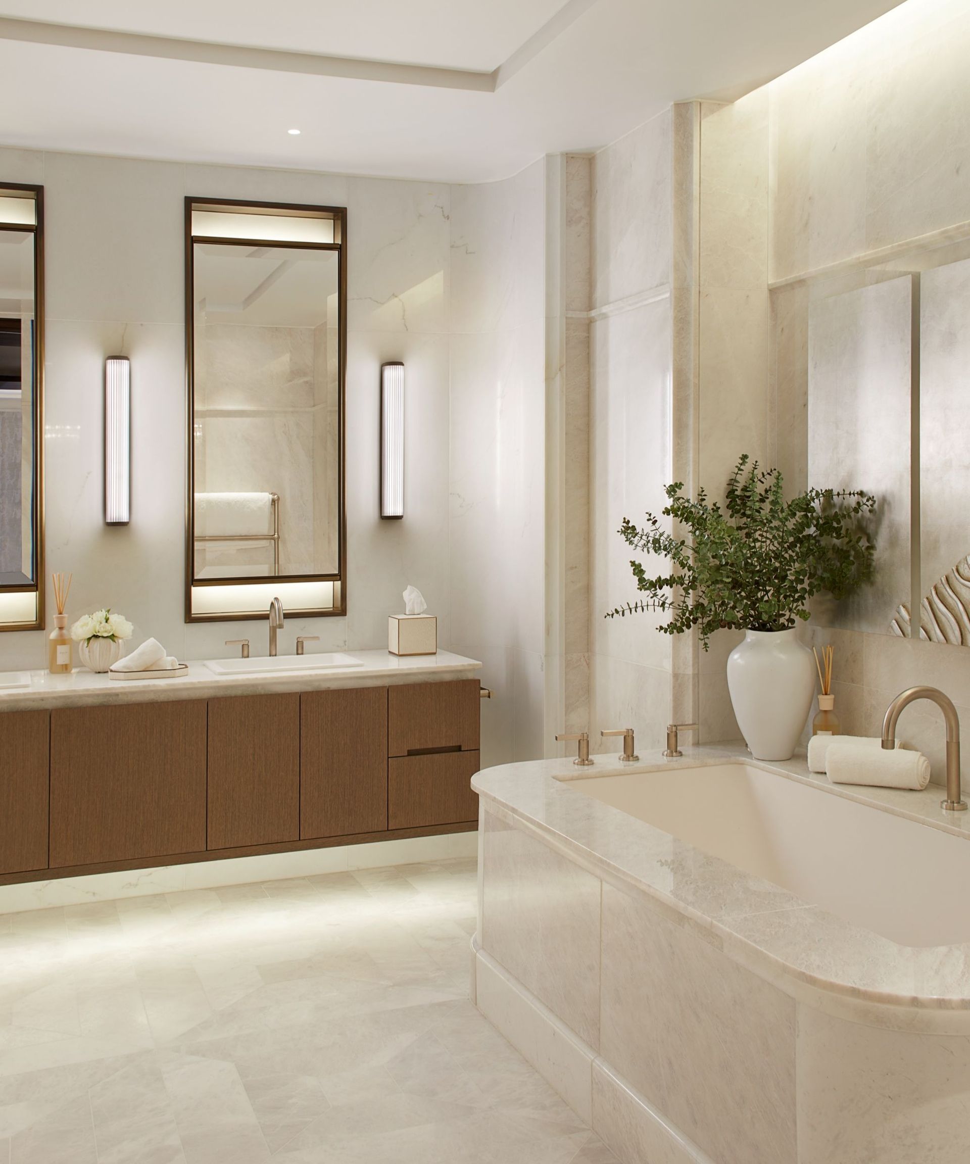 A luxury bathroom with an alcove bathtub, neutral tiles, and a wooden vanity