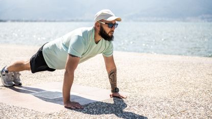 Man holding a plank position outside