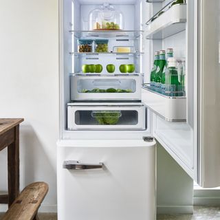 White fridge freezer with different food organised on shelves