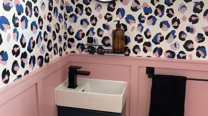 small downstairs loo with pink wall panelling and animal print wallpaper