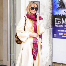 Jennifer lawrence wears a trench coat and scarf.