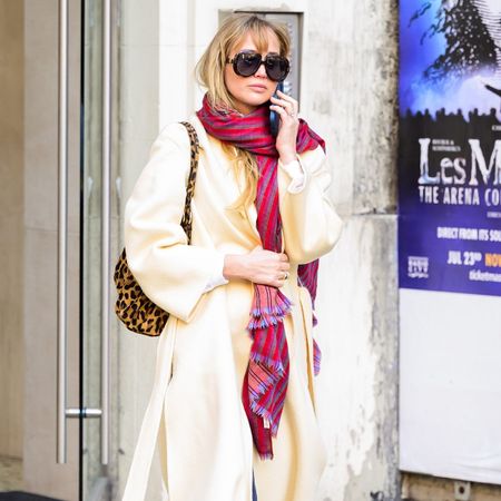 Jennifer lawrence wears a trench coat and scarf.