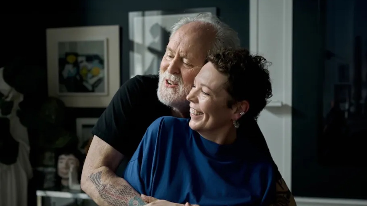 John Lithgow and Olivia Colman smiling while cheek to cheek in Jimpa