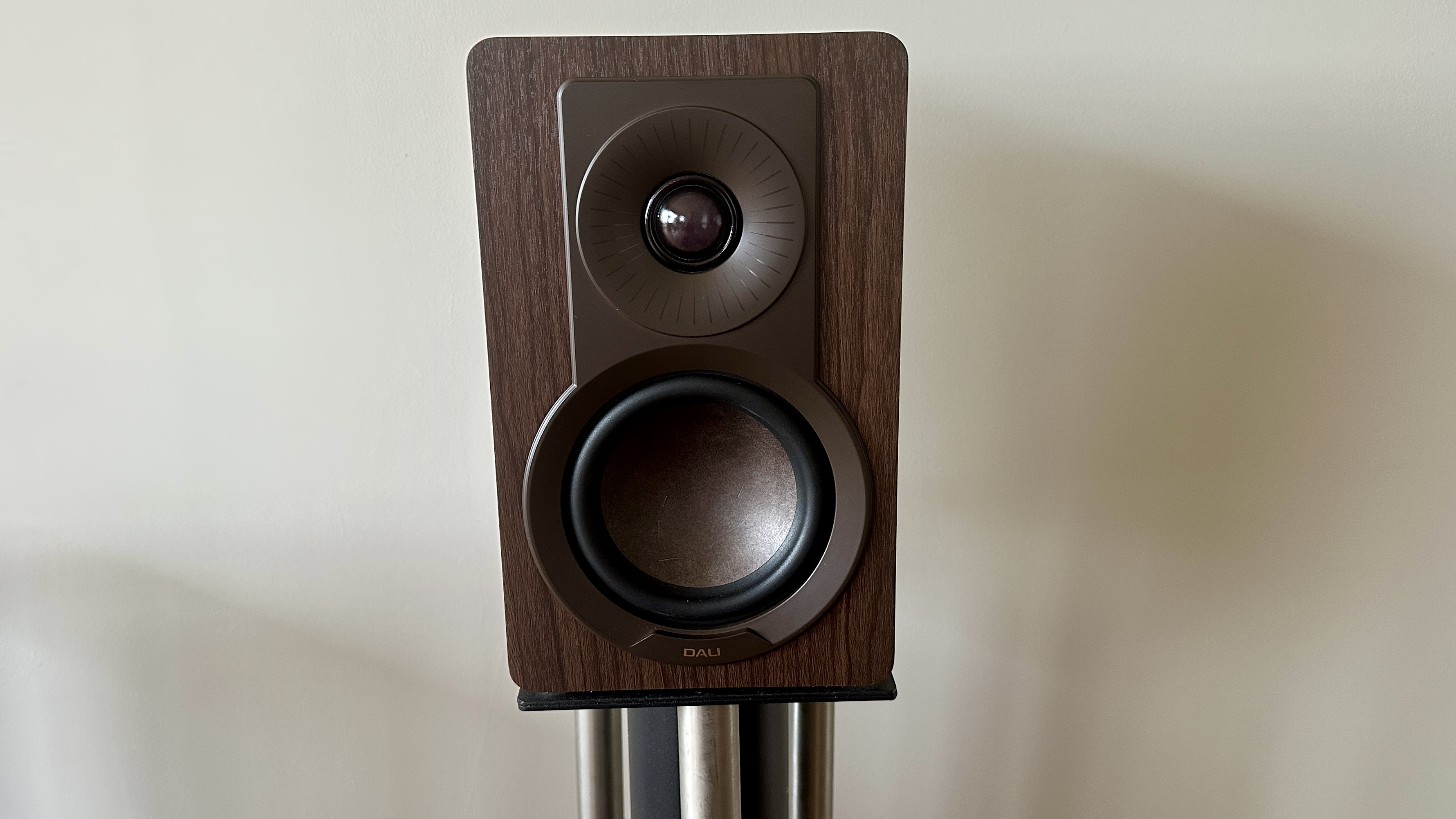 A single Dali Kupid bookshelf speaker, mounted on a speaker stand.