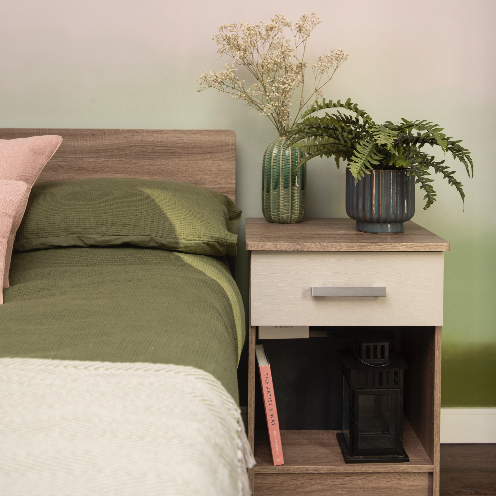 green bedding with wooden bed and bedside table