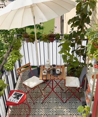 small patio with a table and chairs and a white patio umbrella