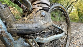 A very muddy boot on a very muddy trail