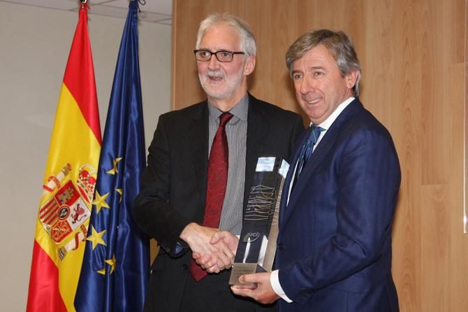 Brian Cookson presents the team trophy to Movistar's Eusebio Unzue