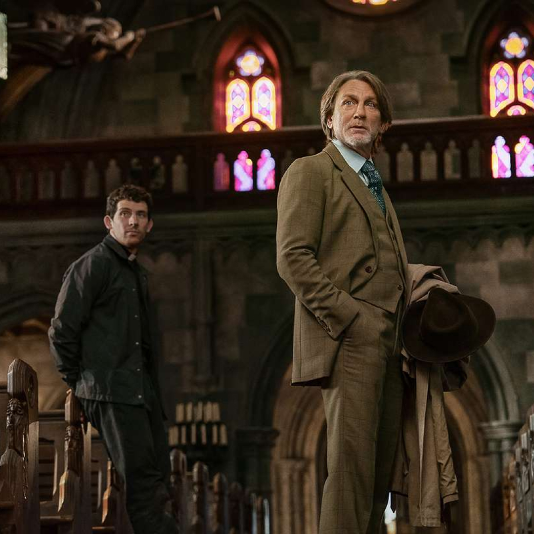 josh oconnor as a priest and daniel craig as benoit blanc standing in a church in wake up dead man a knives out mystery