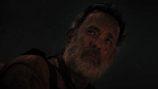 Tom Hanks looks worried in a dark setting in Finch.