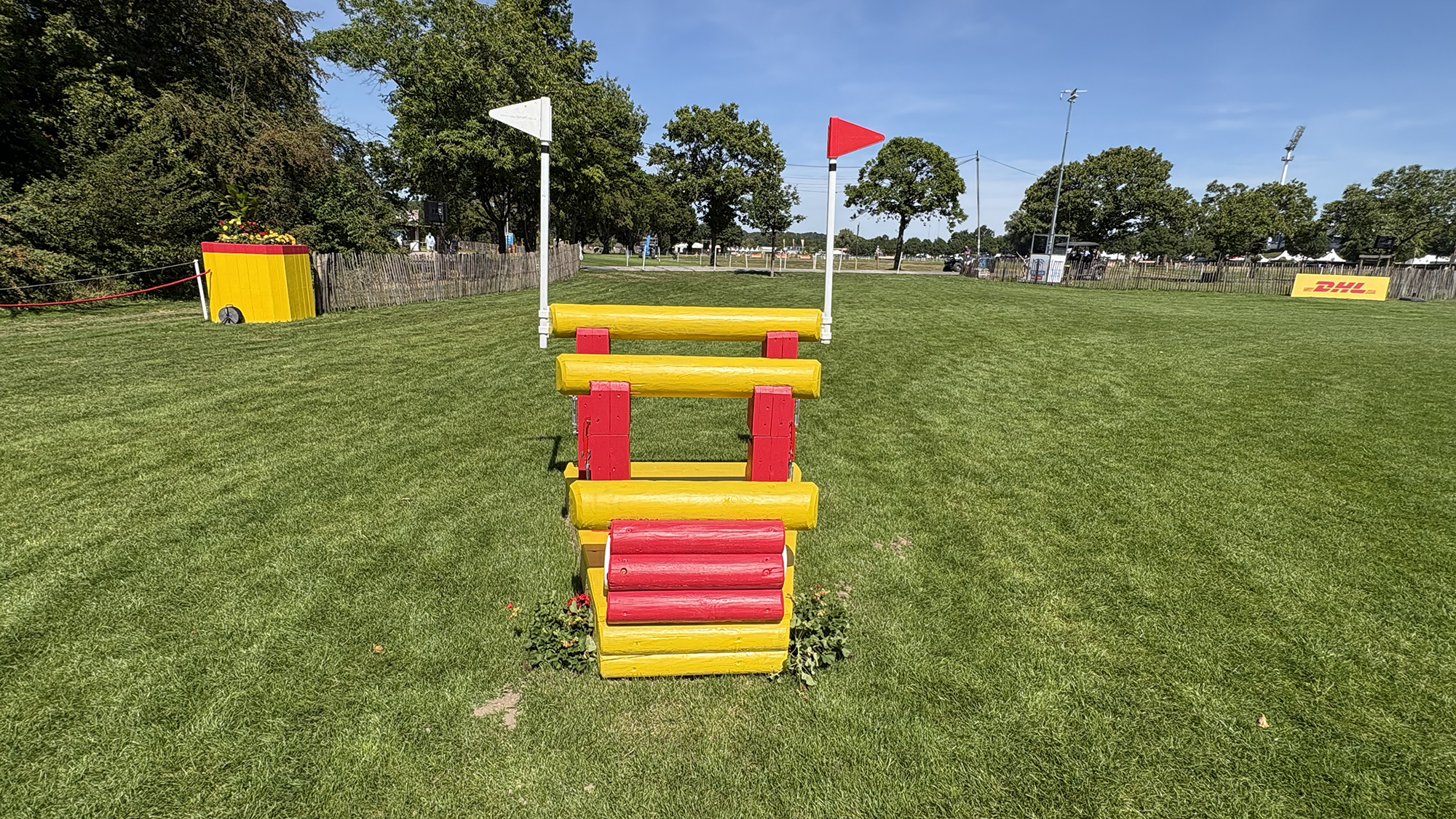 A yellow and red triple bar skinny on the eventing World Championships cross-country course