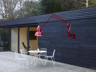 red outdoor lamp from nest on decking
