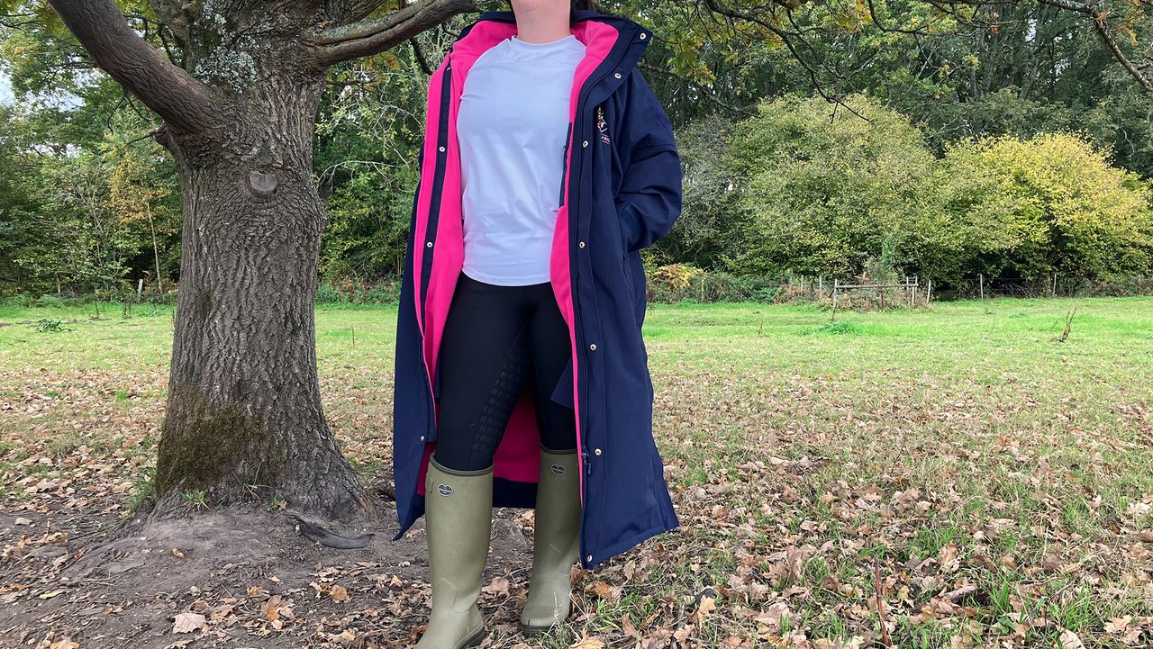 Lady wears Rydale Utility Changing Robe standing by a tree coat unzipped viewed from the front