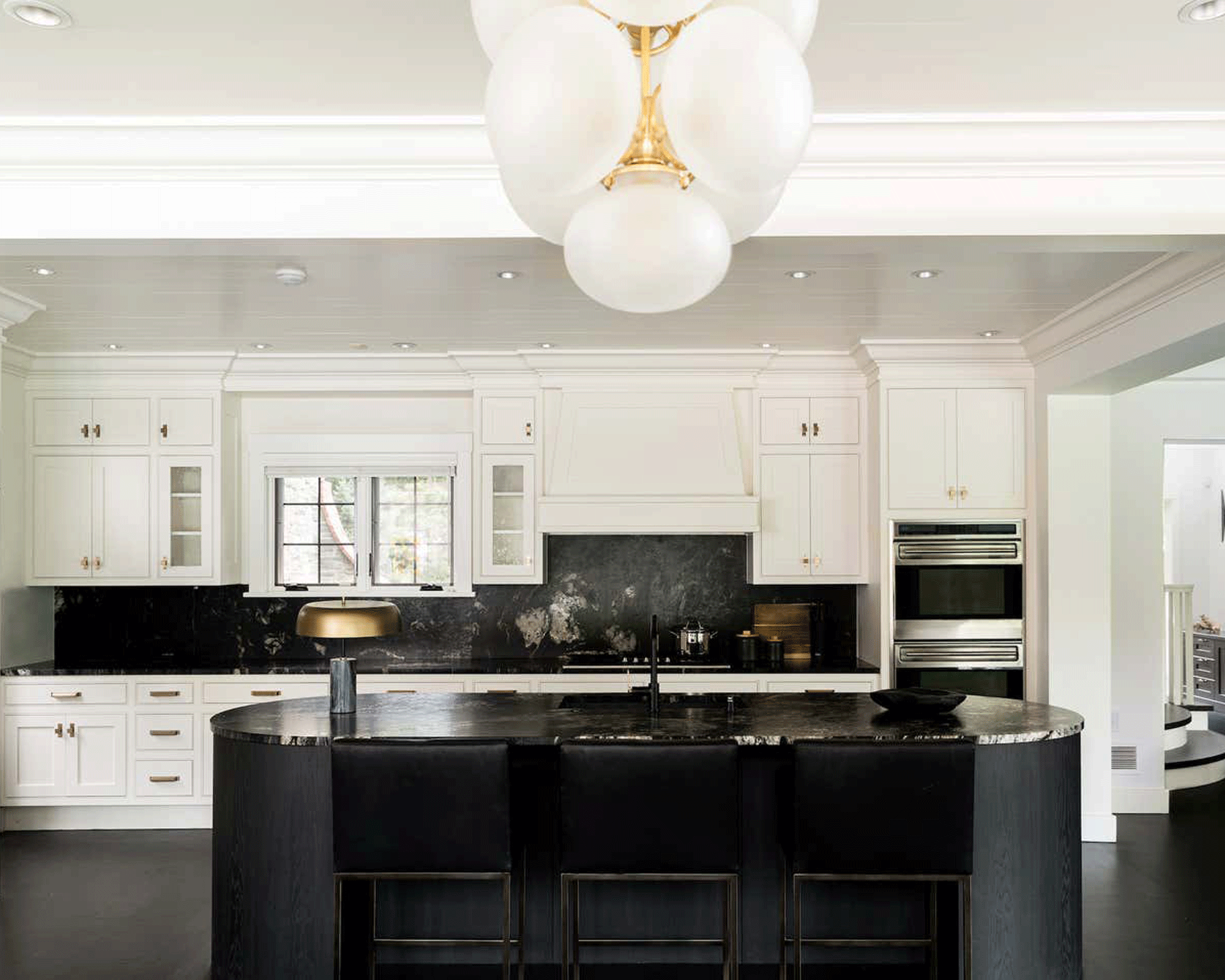 Black and white kitchen with black pill-shaped island