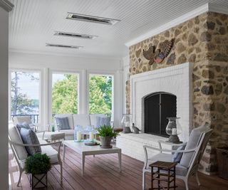 porch with stone fireplace and windows all round with lake view