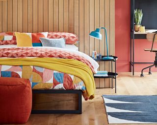 a bedroom with cushions on the bed, wood panelling and modern lighting - habitat