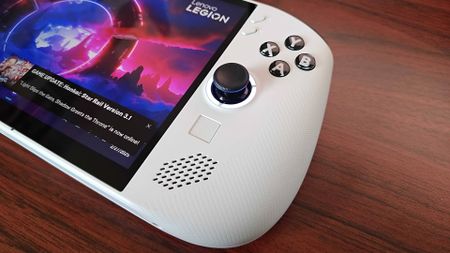 Close up of Lenovo Legion Go S handheld on woodgraind desk.