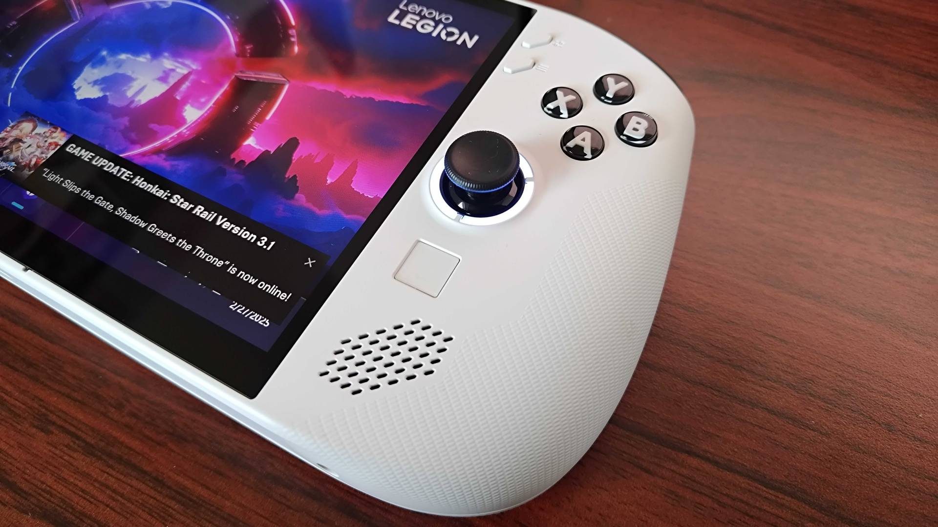 Close up of Lenovo Legion Go S handheld on woodgraind desk.
