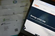 Ofgem energy price cap website on laptop screen beside energy bill statement.