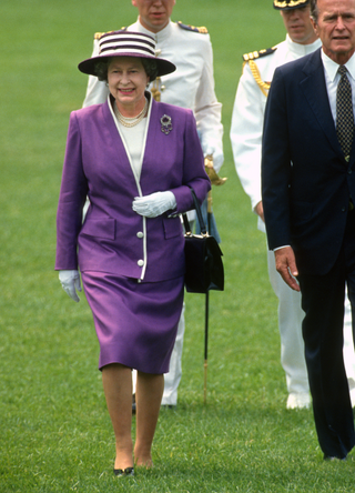 British monarch Queen Elizabeth II (left) and US President George HW Bush (1925 - 2018) walk together on the White House's South Lawn, Washington DC, May 14, 1991