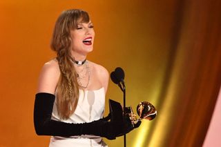 Taylor Swift onstage at the Grammys wearing a braid and a Schiaparelli dress