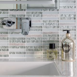 bathroom designed walled tiles with washbasin and hand wash bottle