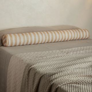 a long bolster on a bed