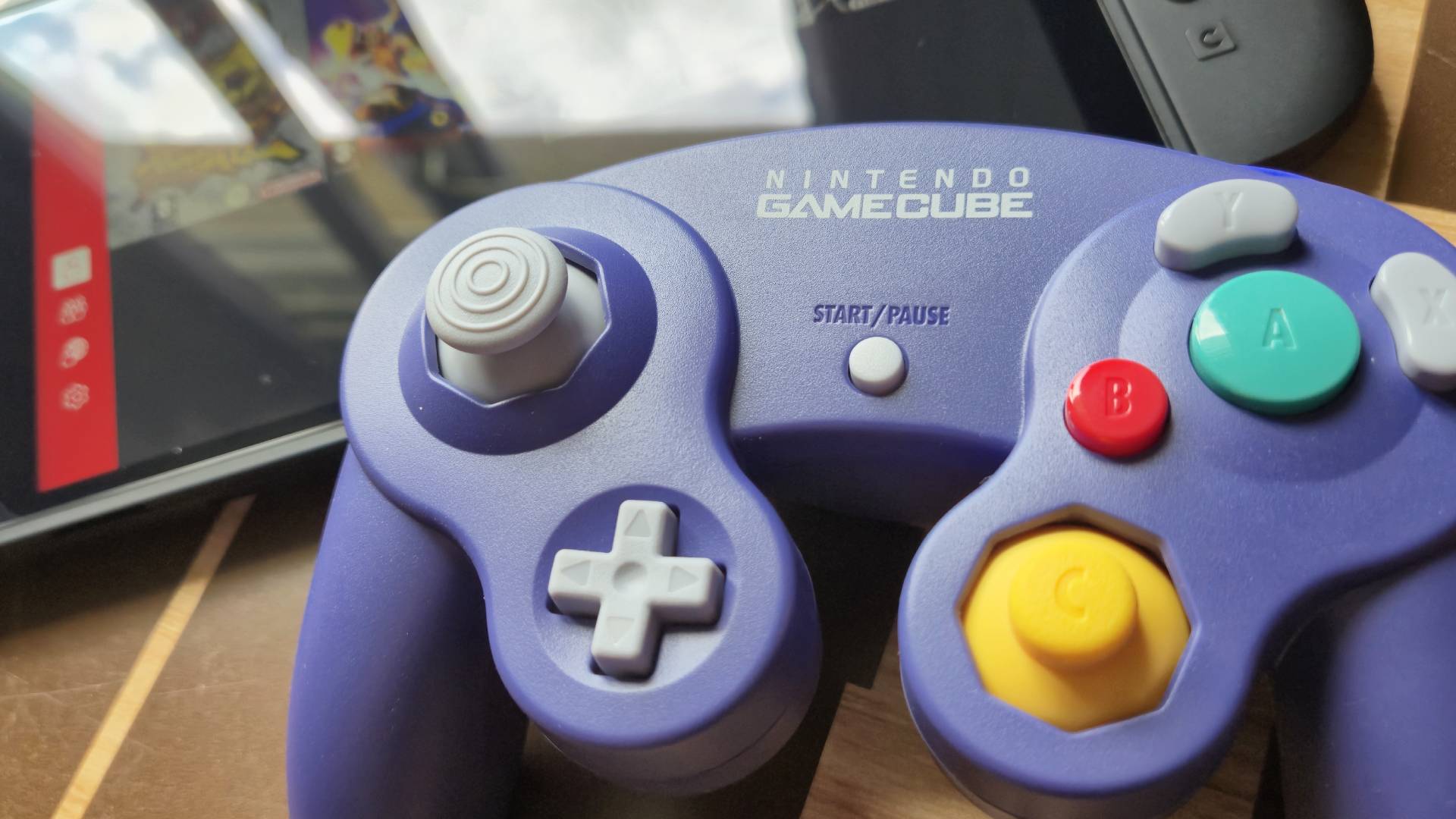 Photo by Rosalie Newcombe of the Switch 2 GameCube controller sitting on the edge of the handheld.
