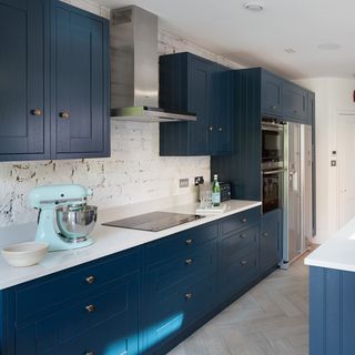 kitchen with white wall blue cabinets and wooden flooring