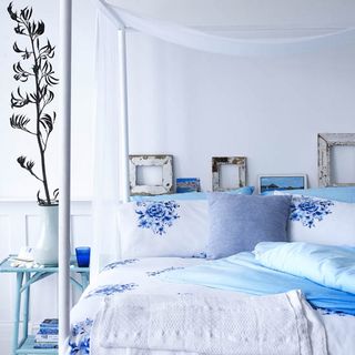 bedroom with white wall and blue and white floral bedlinen