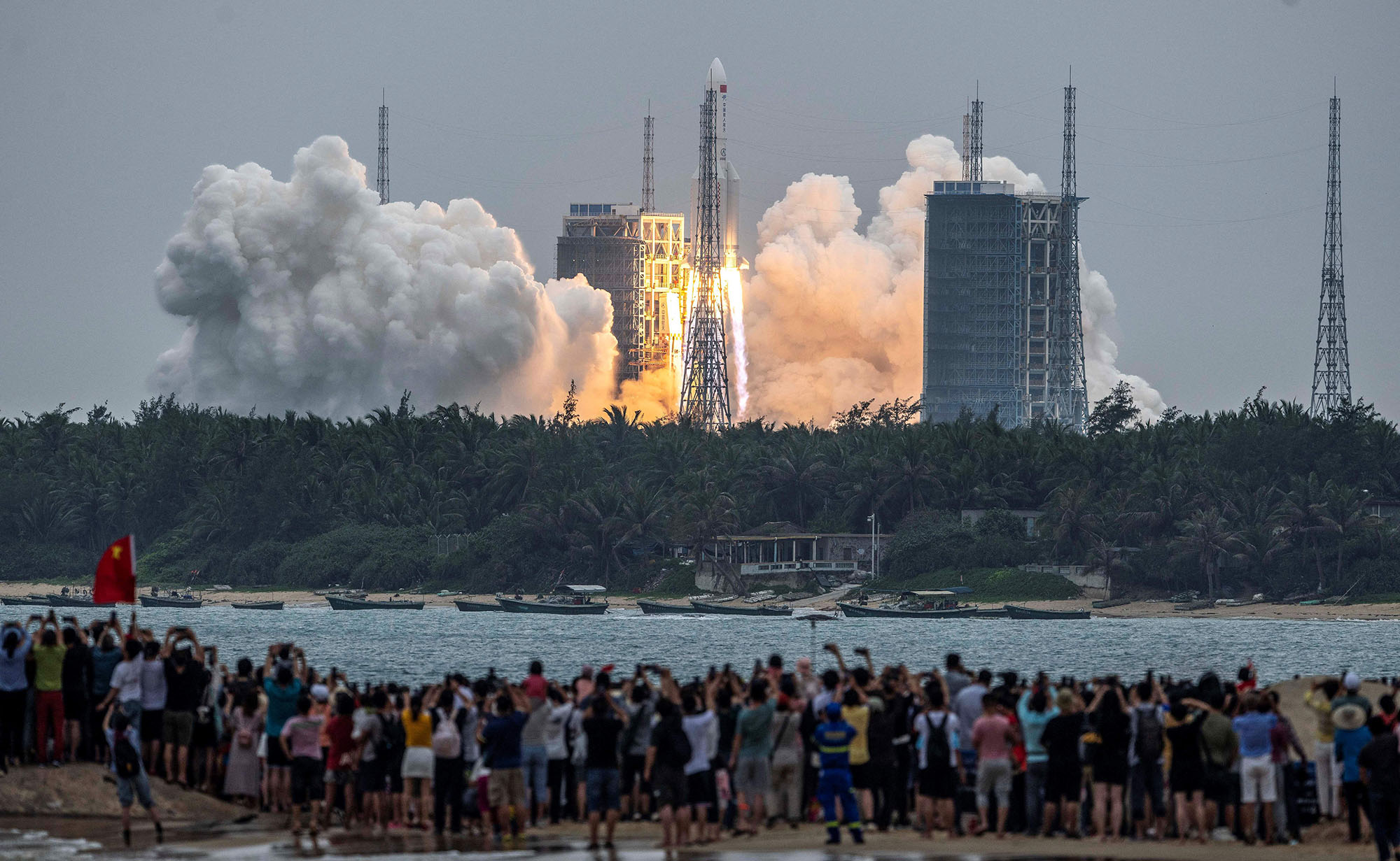 يشاهد الناس صاروخ Long March 5B ، الذي يحمل الوحدة الأساسية لمحطة Tianhe الفضائية الصينية ، وهو ينطلق من مركز Wenchang للإطلاق الفضائي في مقاطعة هاينان جنوب الصين في 29 أبريل 2021 (مصدر الصورة: STR / AFP / Getty) 