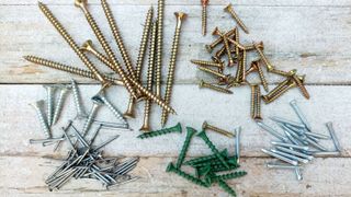Selection of nails and screws on whitewashed wood