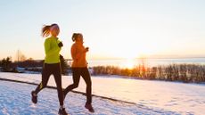 Two women running in the snow