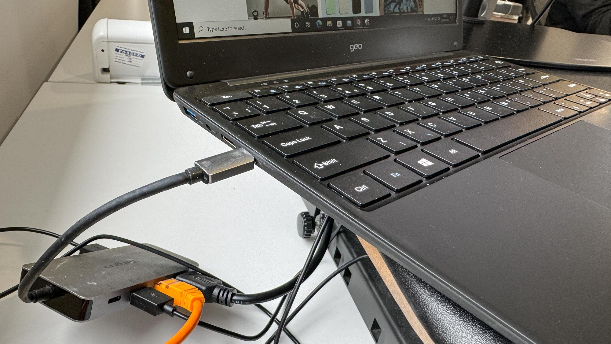 The Geobook 2E budget laptop ports with a dongle attached to an external monitor and keyboard