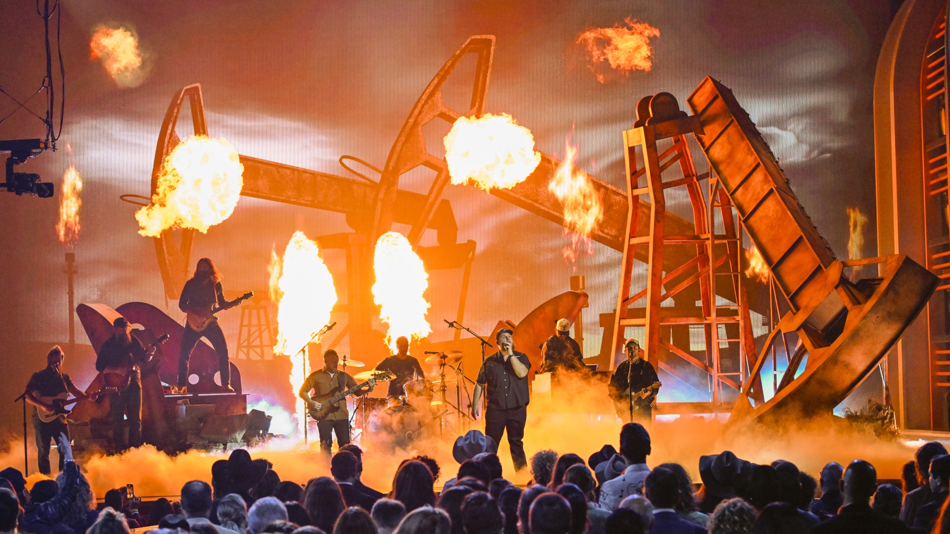 Luke Combs performing against a backdrop of pyrotechnics at the CMA Awards at Bridgestone Arena in 2024