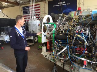 Harry van Hulten, director of flight testing at XCOR Aerospace, with the engine assembly for the company's Lynx space plane, which is currently in development.