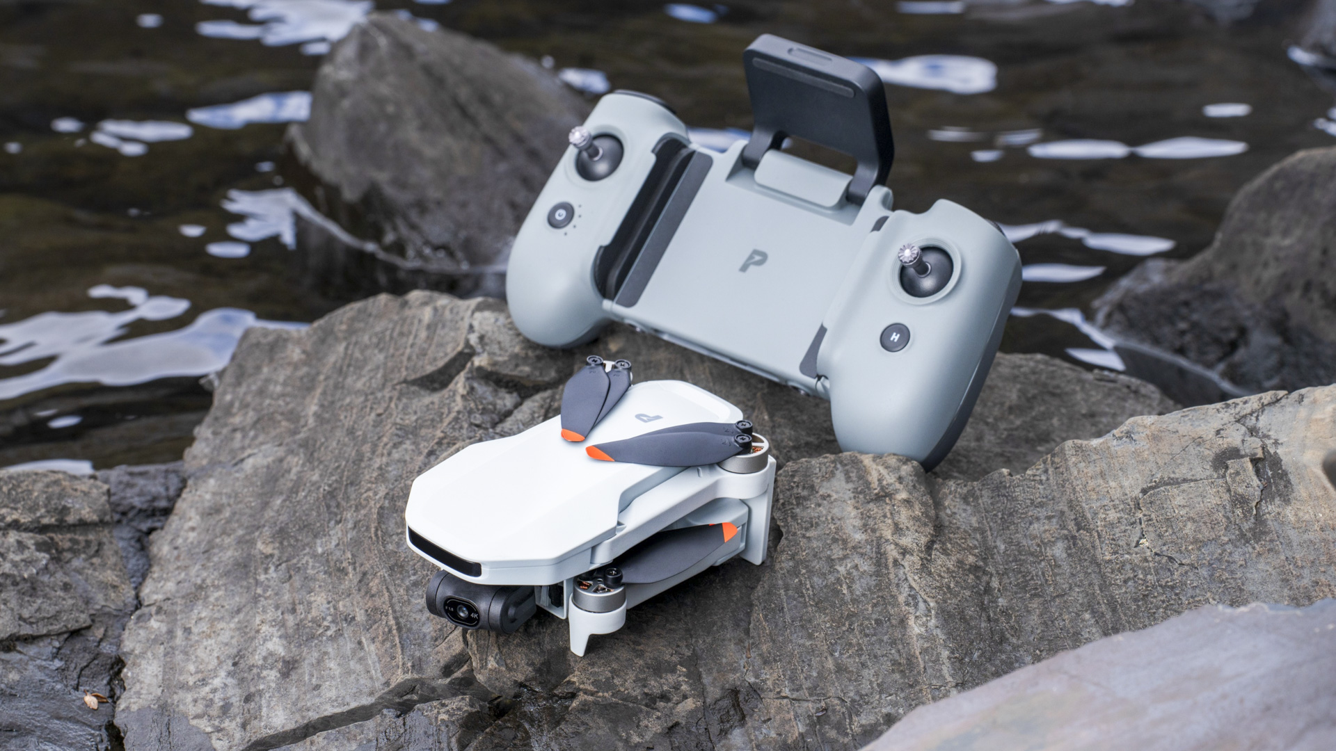 Potensic Atom 2 drone folded alongside the controller, on a rock