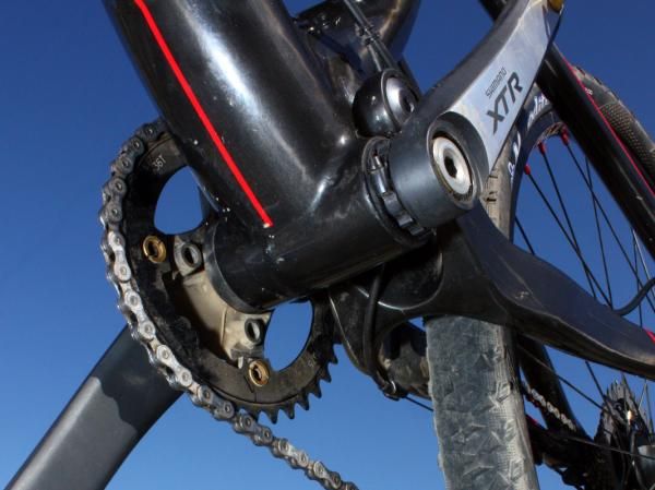 Main pivot bearings are widely set to prevent lateral and torsional flex. Mud clearance looks quite good, too, and the front derailleur cable stop is integrated into the chain stay on its way up to the swingarm-mounted front derailleur.