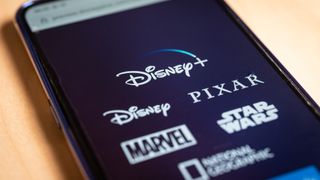 A mobile phone showing the Disney Plus logo and some of its subsidiary studios