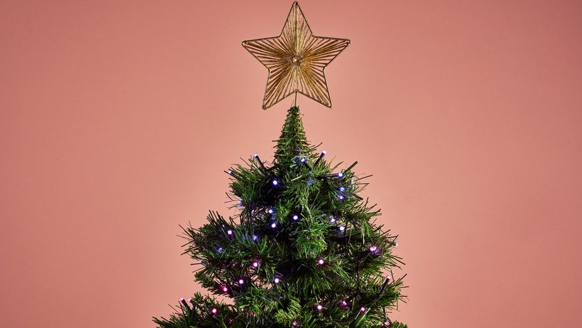 The Nanoleaf Smart Holiday String Lights are glowing pink and purple on a Christmas tree.