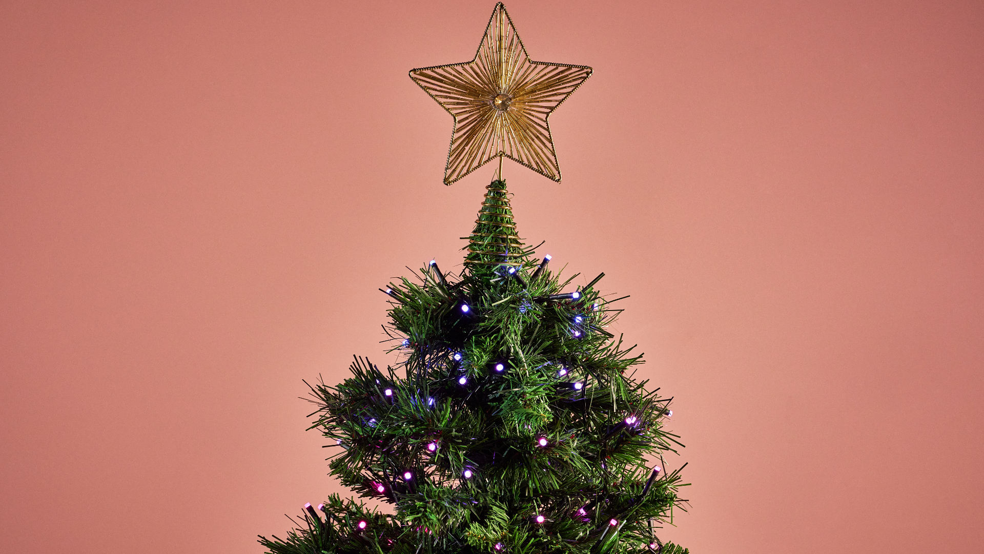 The Nanoleaf Smart Holiday String Lights are glowing pink and purple on a Christmas tree.