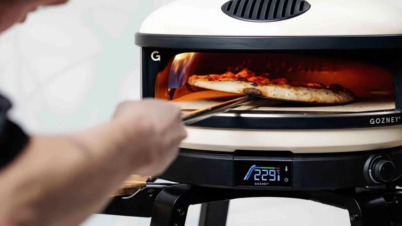 The Gozney Arc Pizza Oven, lit and being used to cook