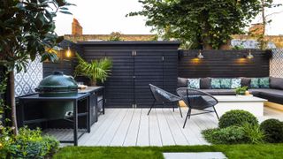 contemporary garden with outdoor furniture and well lit fencing