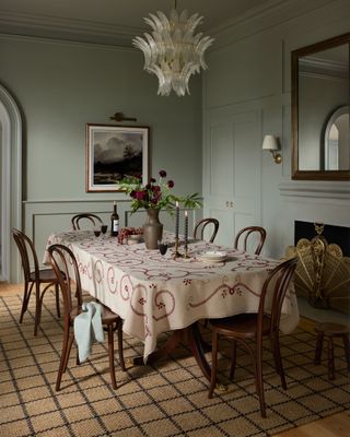 CLJ x Loloi Rugs Checkered Rug in a fall, cozy dining room. The table has a red and white table cloth and six wooden chairs