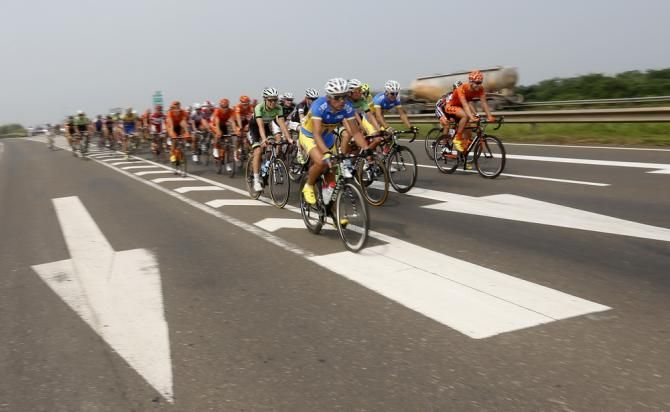 The peloton rolls along in the sunshine at Tour of Hainan